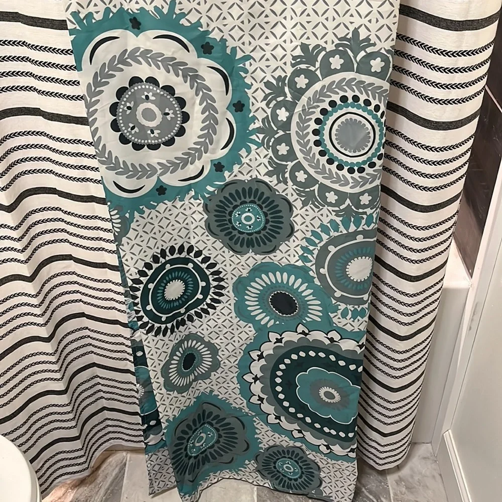 Shower curtain with teal flower design at bottom